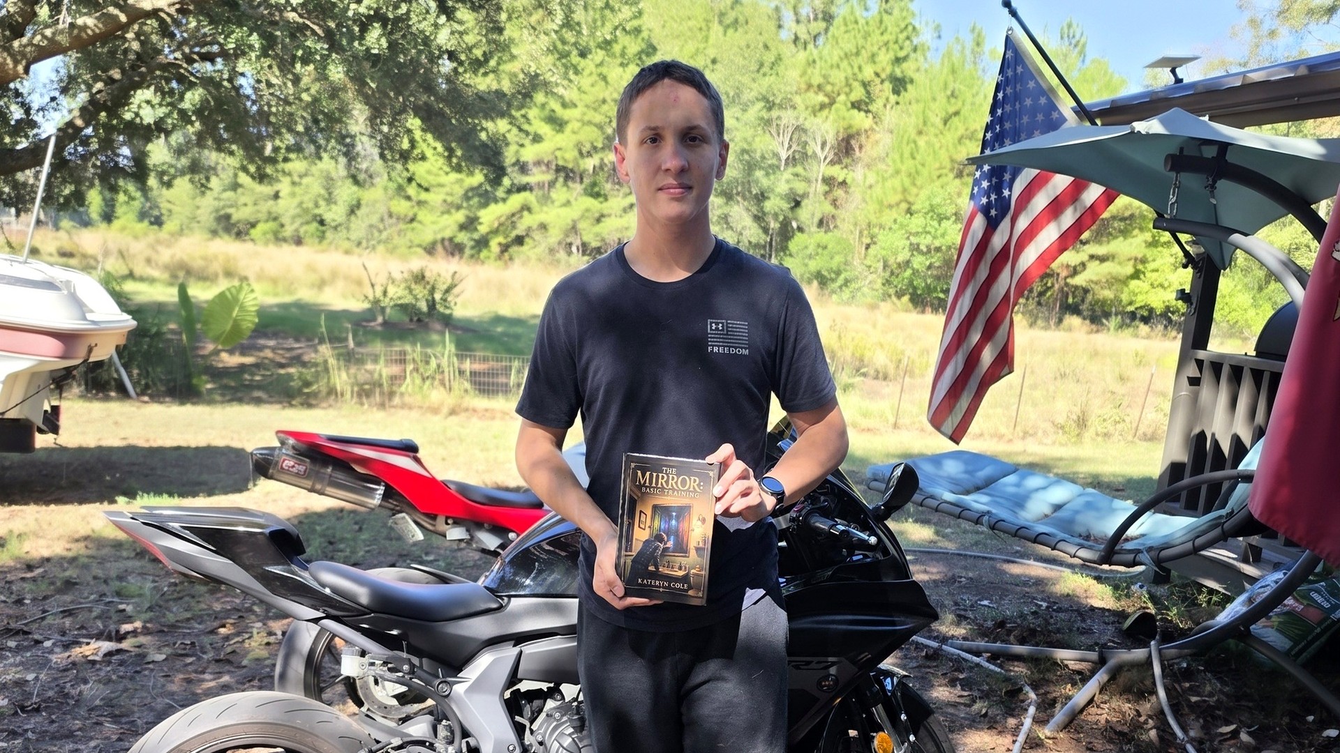 Author Kateryn Cole's son holding a copy of The Mirror: Basic Training.