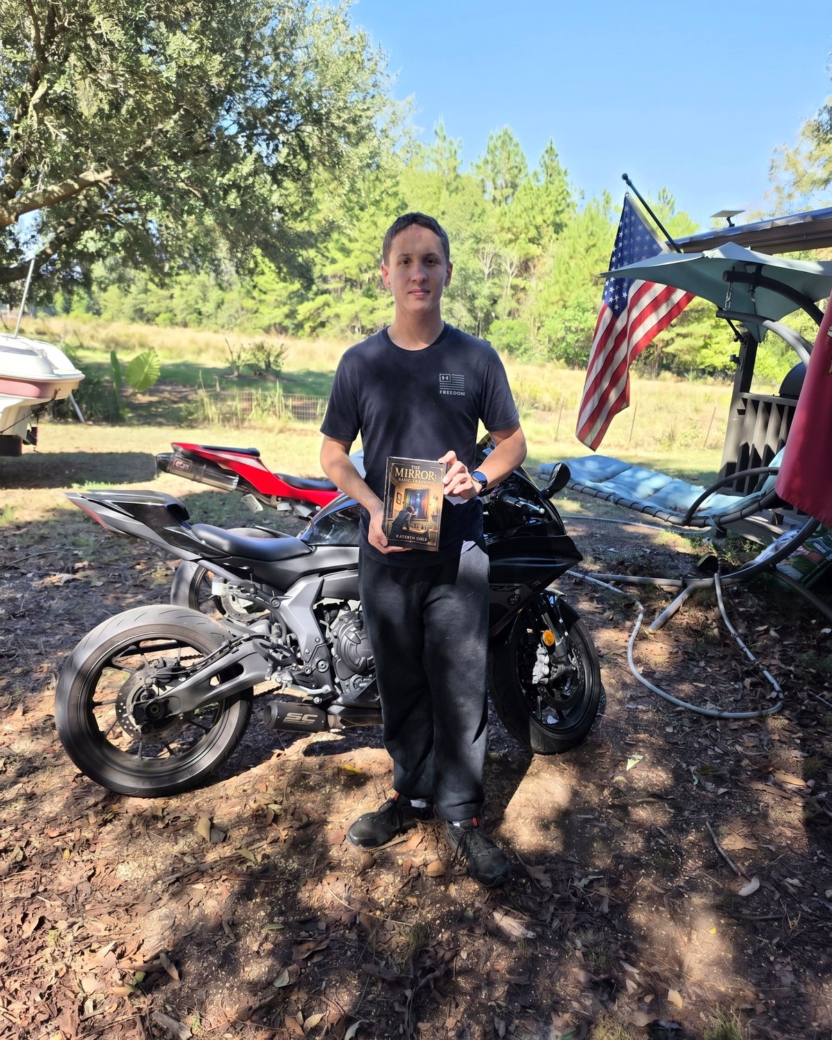 Author Kateryn Cole's son holding a copy of The Mirror: Basic Training.